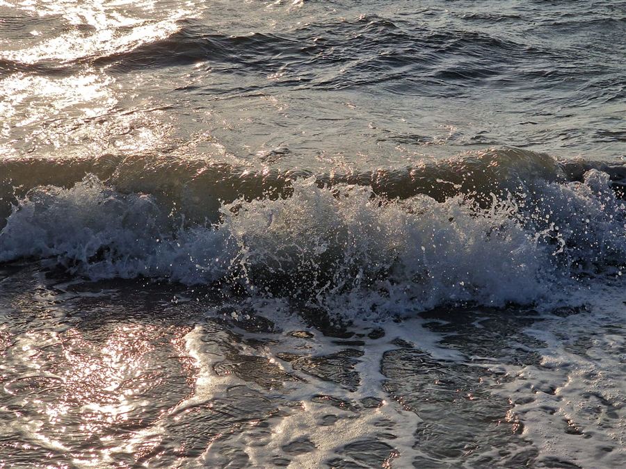 Welle, die am Nordseestrand aufläuft
