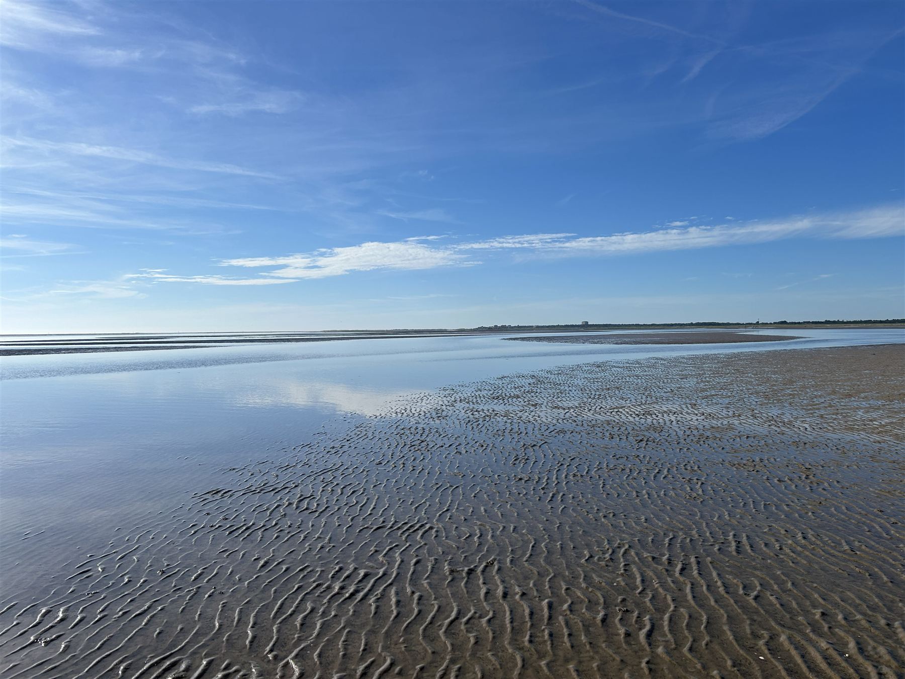 Watt bei St. Peter-Ording, Schleierwolken spiegeln sich im flachen Wasser über Sandrippen